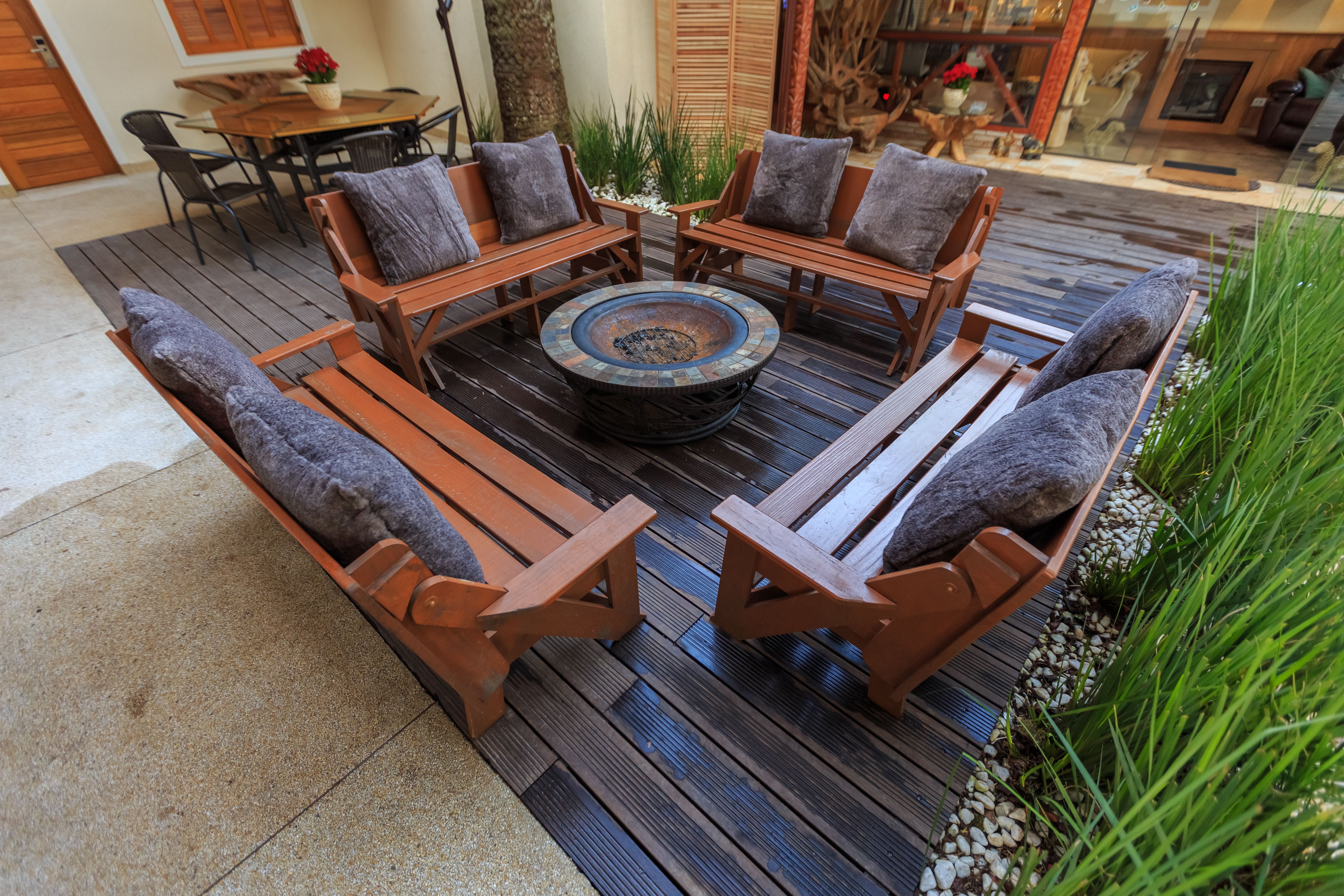 Outdoor backyard lounge with benches and a central fire pit for gatherings.